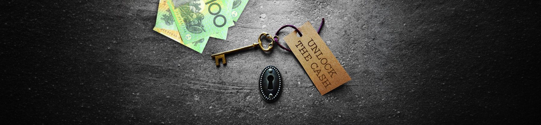 A key and Australian banknotes beside a tag reading Unlock The Cash.